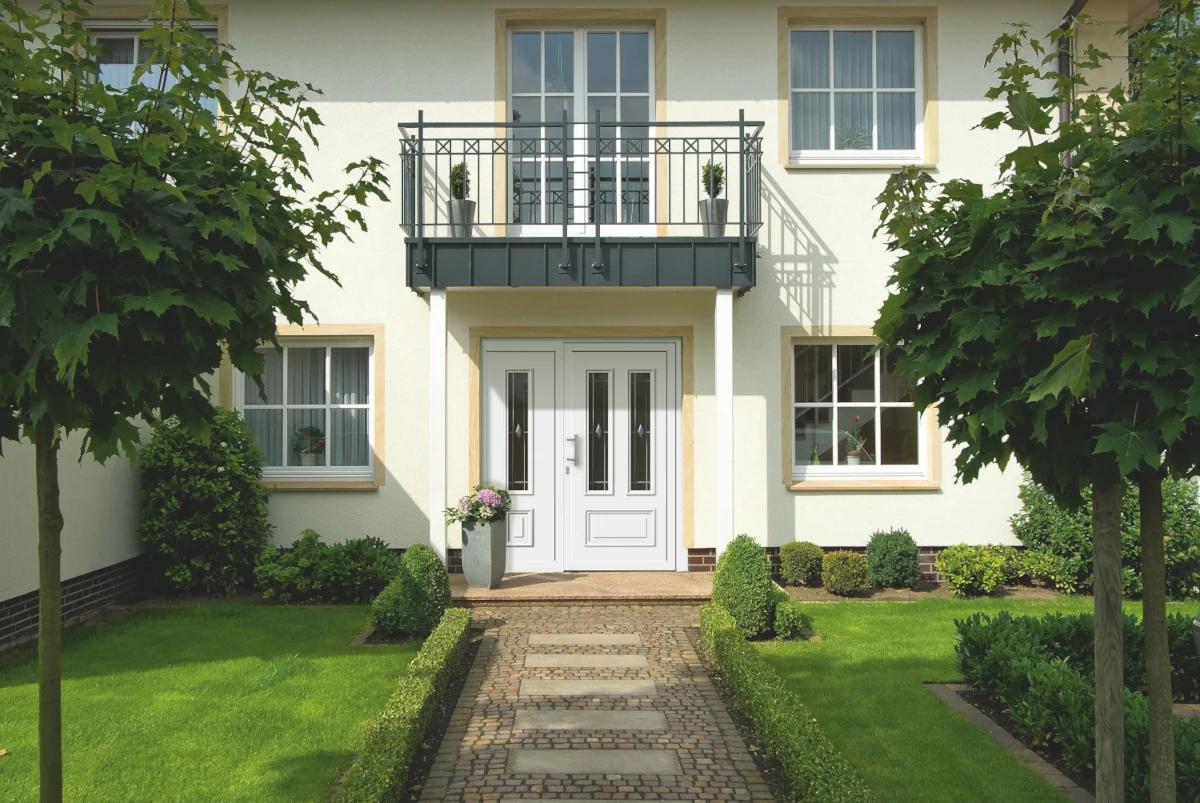 Eingangsbereich eines Einfamilienhauses mit Balkon, Garten und Haustür